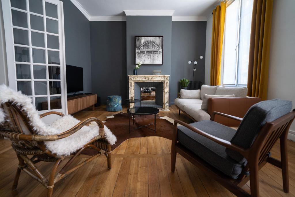 ein Wohnzimmer mit einem Sofa und einem Kamin in der Unterkunft Centre ville - Appartement 3 chambres & Terrasse - La Clé des Sacres in Reims