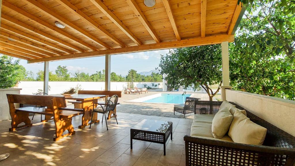 a patio with a wooden pergola and a table and chairs at Villa Legacy in Krušvar