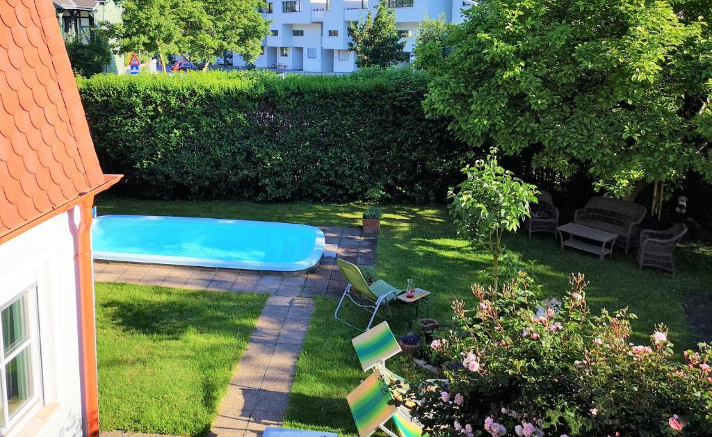 een achtertuin met een zwembad en enkele stoelen bij Christl - Apartment mit Garten und Pool zur Mitbenutzung in Wenen