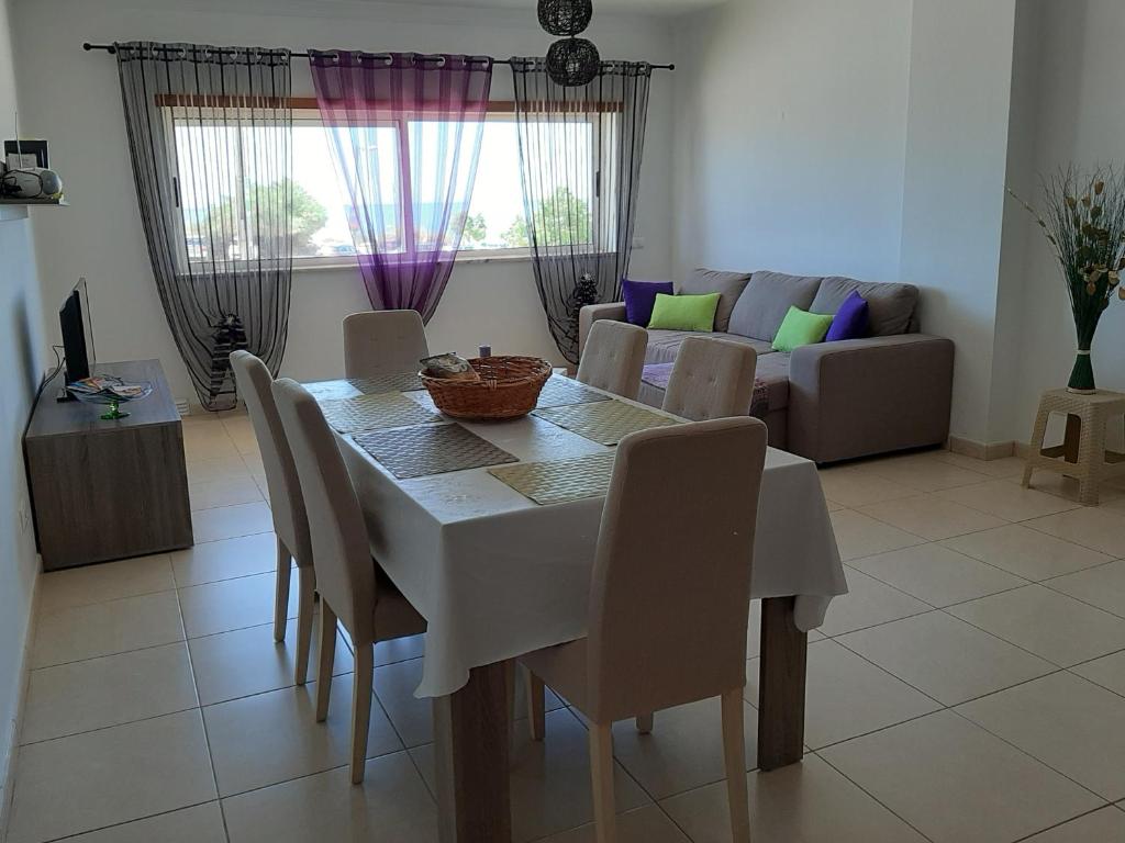 a dining table and chairs in a living room at Edificio Praia Mar Sol in Armação de Pêra