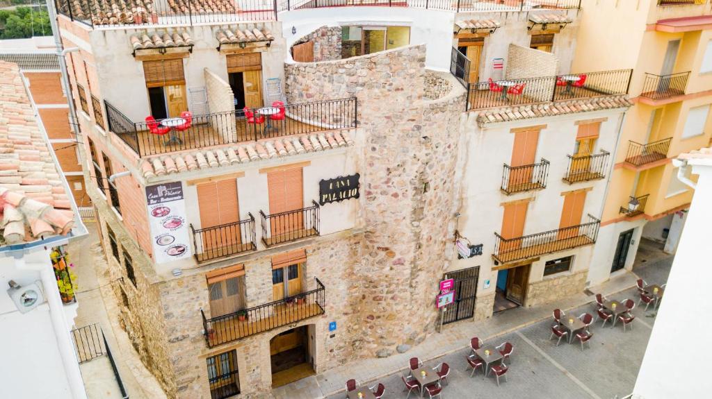 una vista aérea de un edificio con balcones y mesas en Hotel Casa Palacio, en Montanejos