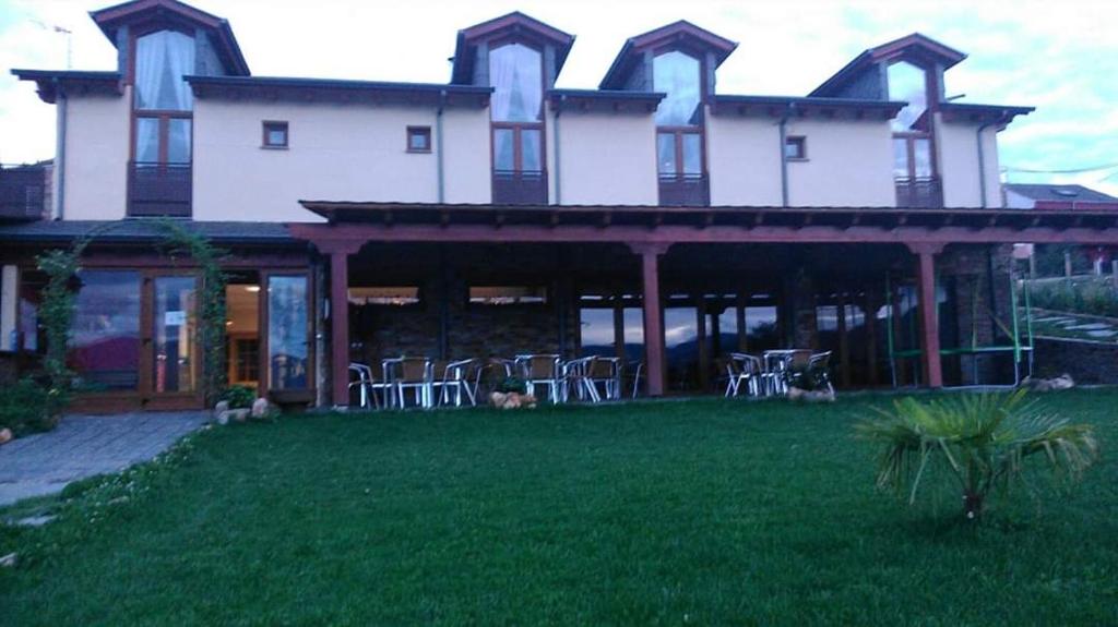 une grande maison avec des chaises sur la pelouse dans l'établissement Casa Rural FULGUERA, à El Espino