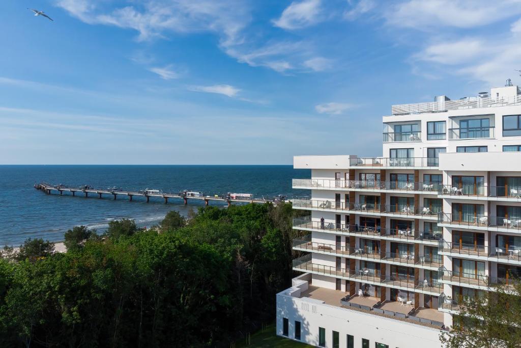 a building overlooking the ocean and a pier at Aquamarina PRIMA Marina Invest in Międzyzdroje