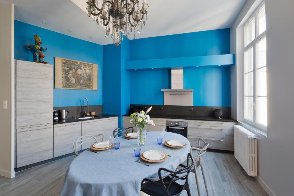 uma cozinha azul com mesa e cadeiras em Le Blue Note by Cocoonr - Bel appartement de standing em Saint Malo