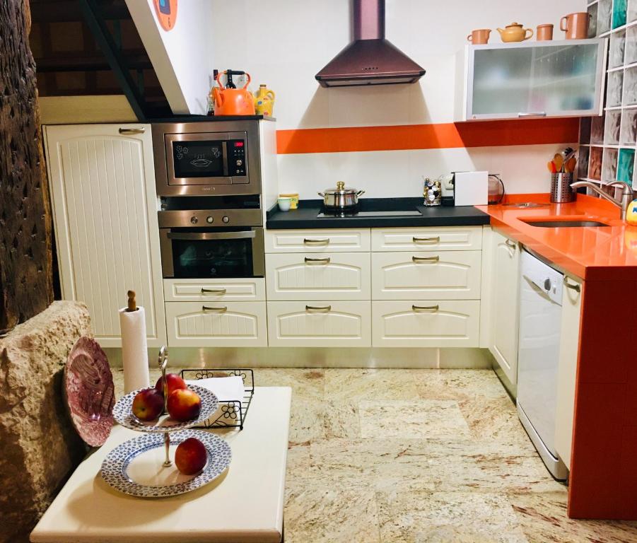 una cocina con armarios blancos y una mesa con fruta. en Casa Berganzo, Rioja Alavesa, en Berganzo