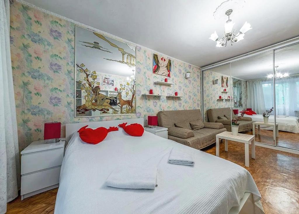 モスクワにあるApartment Hanaka on Bratskaya 15のベッドルーム(白いベッド1台付)、リビングルームが備わります。