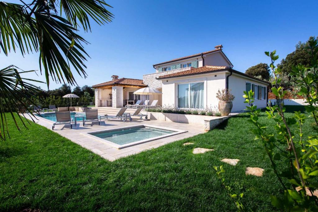 uma casa com piscina num quintal em Mirana Luxury Villas em Kavran