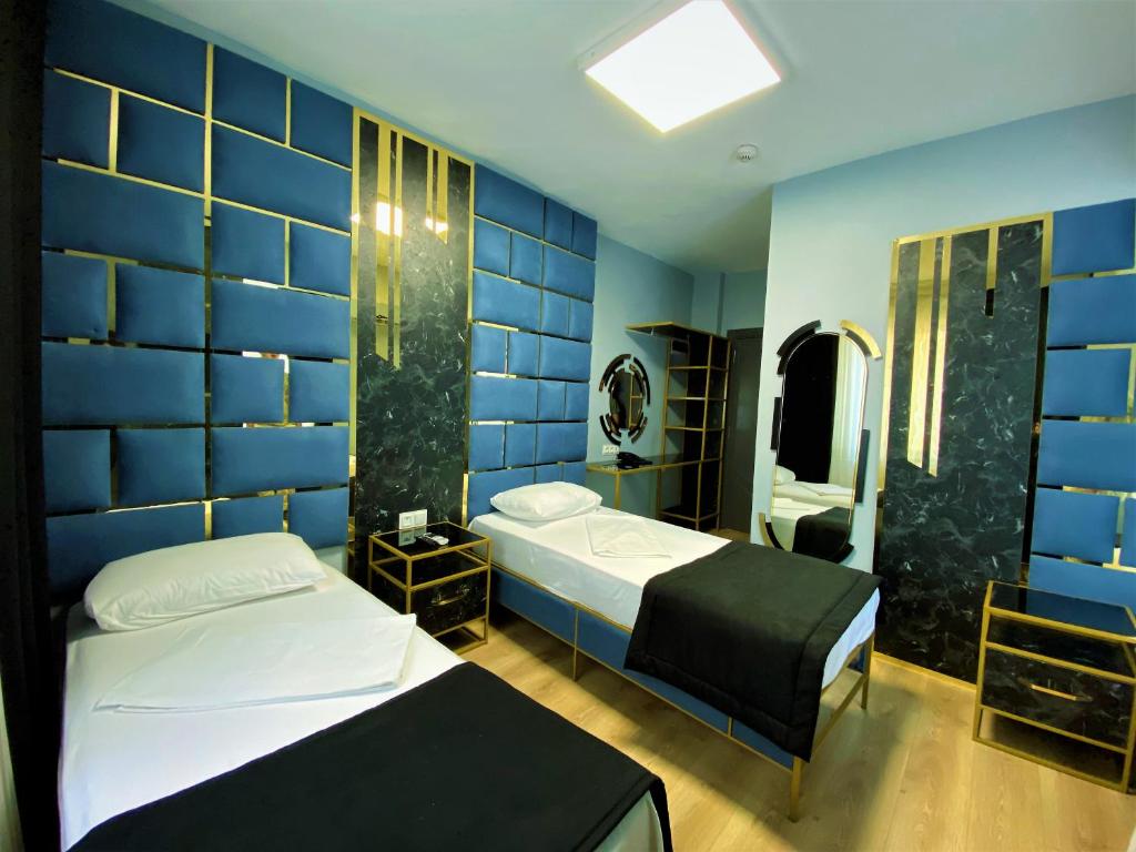 um quarto com 2 camas e uma parede azul em Orange Airport Hotel em Istambul