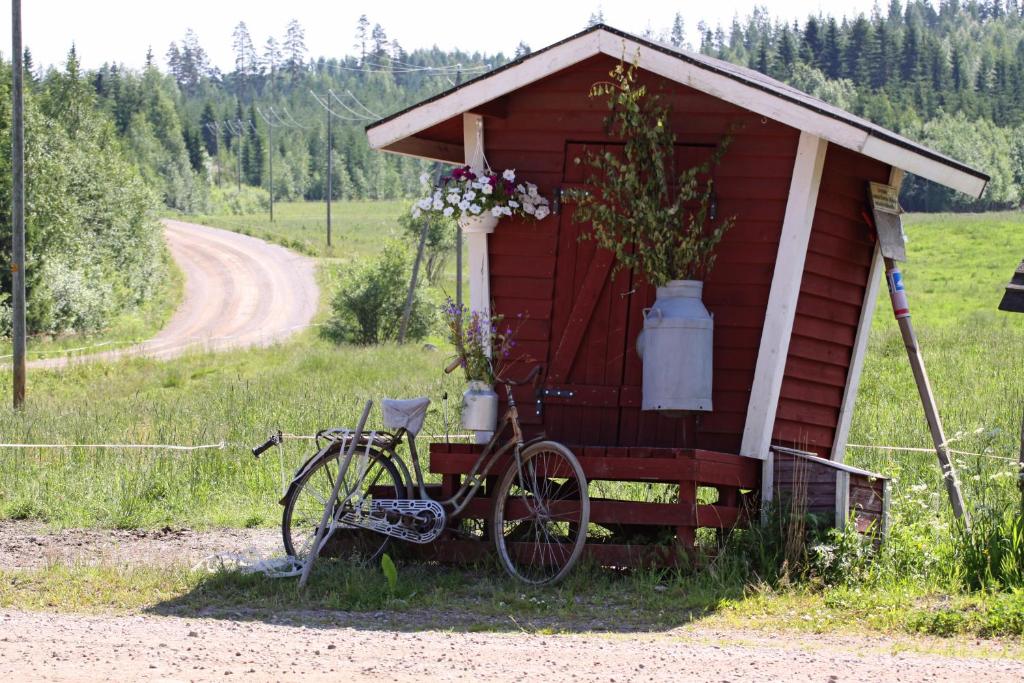 een fiets geparkeerd voor een rode schuur bij Mäkelän Lomatuvat Cottages in Korkeakoski