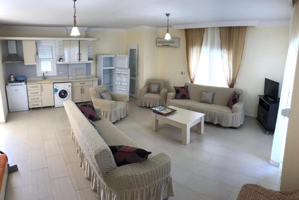 a large living room with couches and a kitchen at Yesilkent Duplex with Pool in Didim