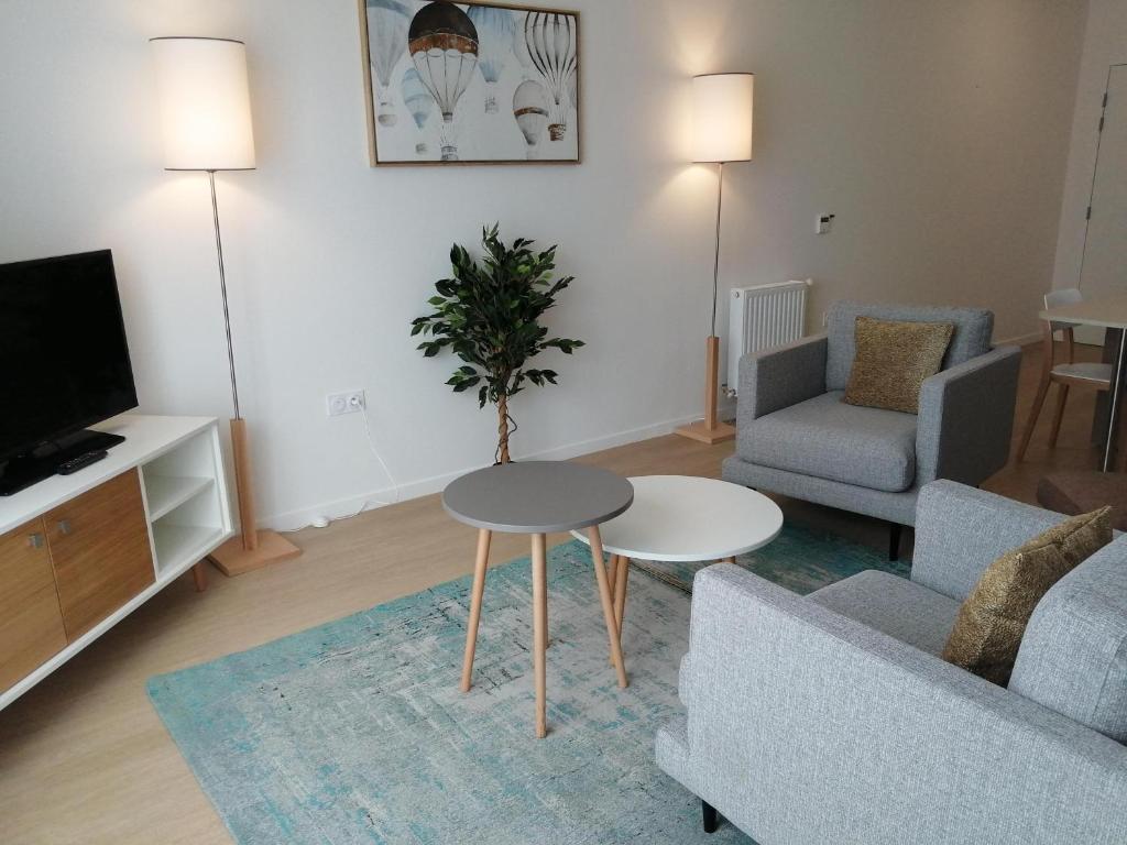 sala de estar con sofá, mesa y TV en DOMITYS - Le Solstice, en Versalles