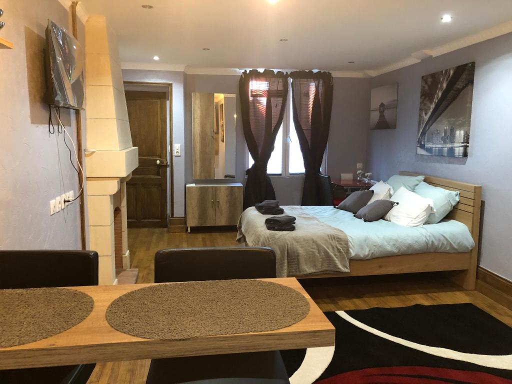 een slaapkamer met een bed en een eettafel bij Studio Chaleureux Blois Centre in Blois