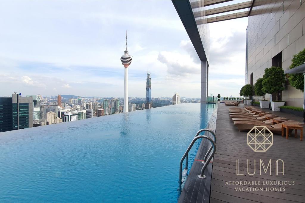 ein Schwimmbad auf dem Dach eines Gebäudes mit einer Stadt in der Unterkunft The Platinum Kuala Lumpur by LUMA in Kuala Lumpur