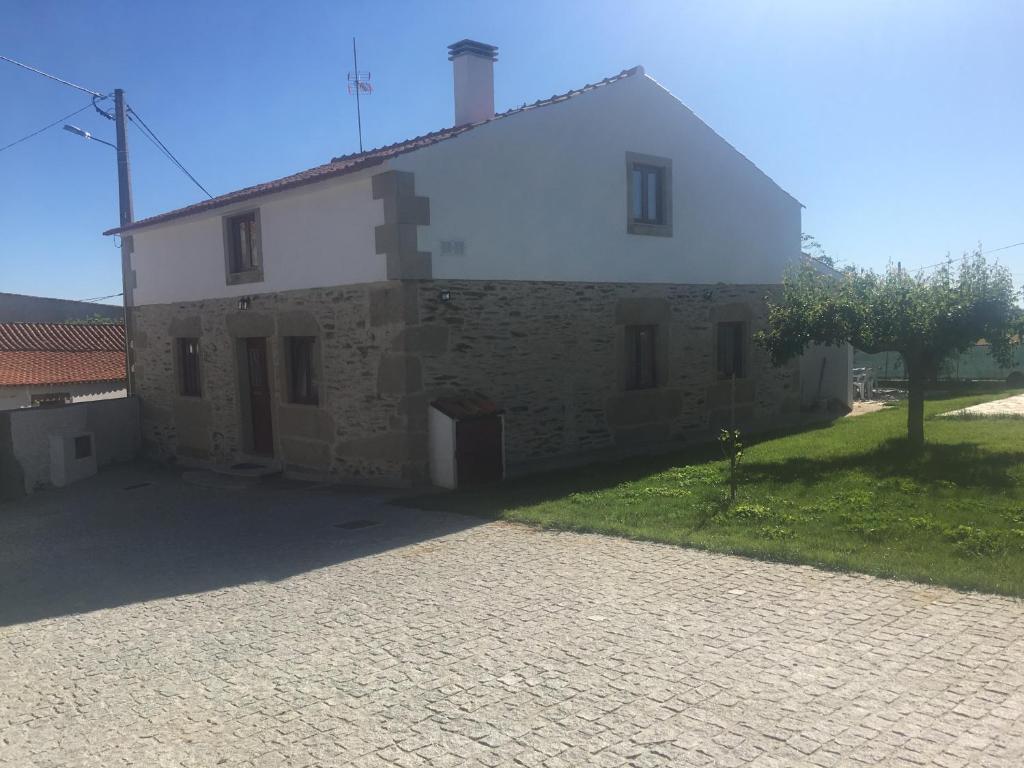 an old stone house with a driveway in front of it at Casadaldeiadalmofala in Almofala