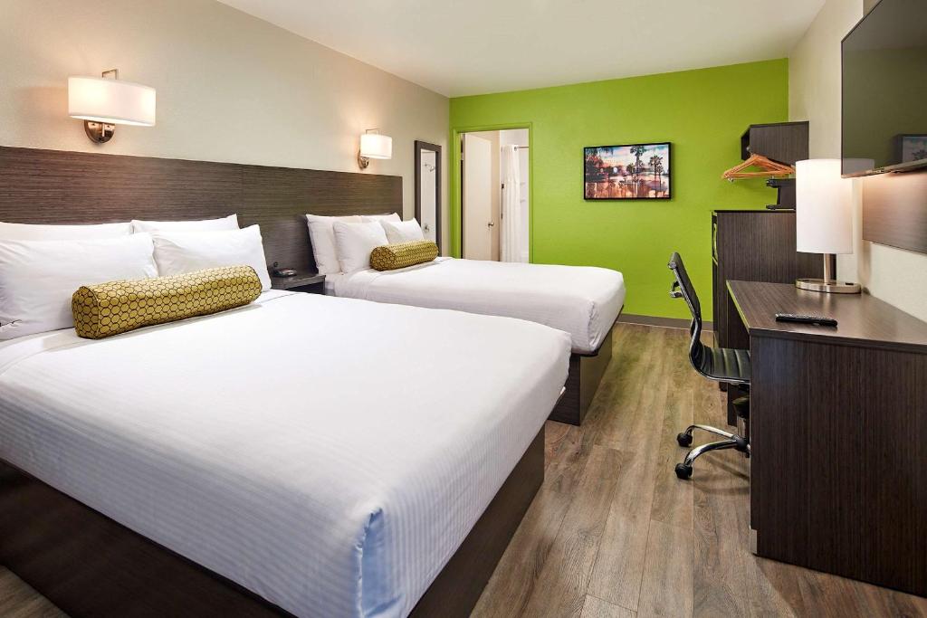 duas camas num quarto de hotel com paredes verdes em SureStay Hotel by Best Western San Diego Pacific Beach em San Diego