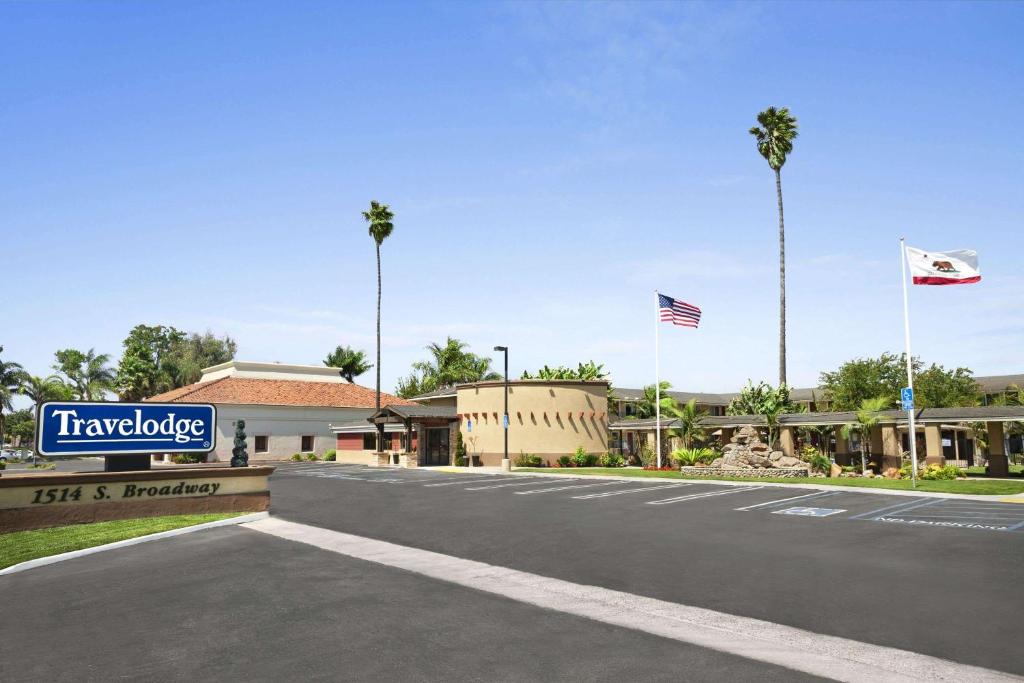 a sign for a hotel on a street with flags at Travelodge by Wyndham Santa Maria in Santa Maria