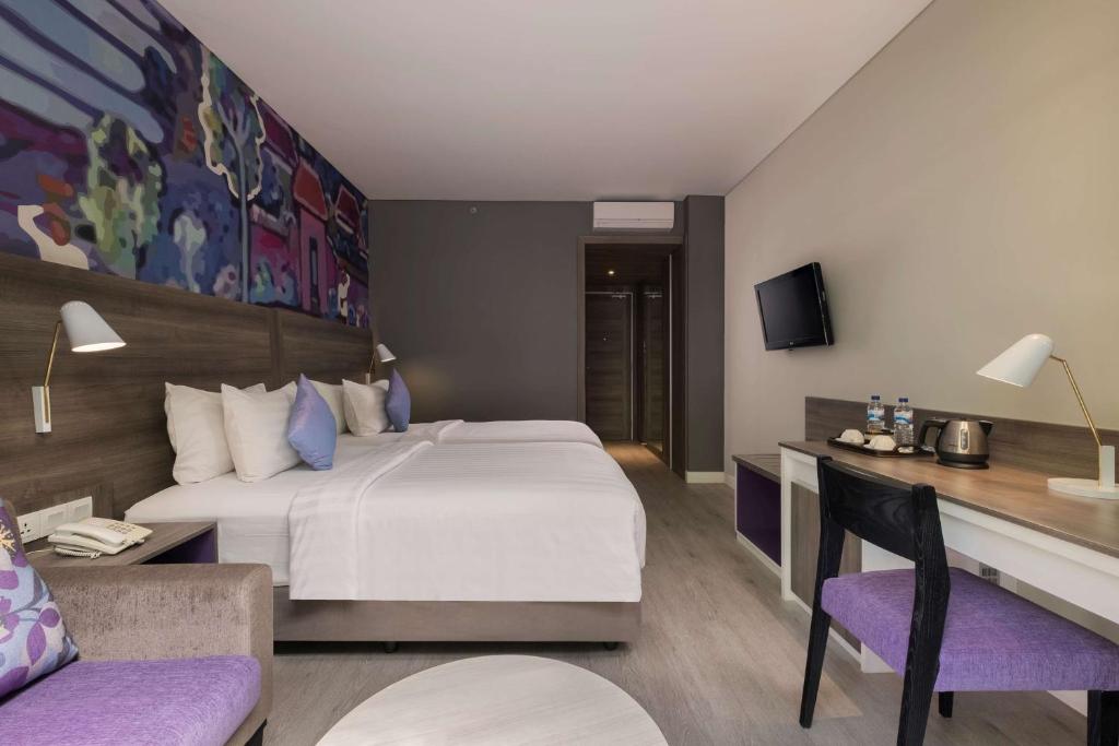 Un pat sau paturi într-o cameră la Wyndham Garden Kuta Beach Bali