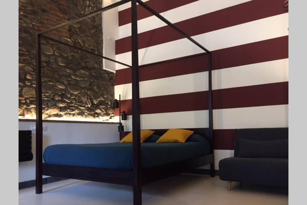 a bed in a room with a striped wall at Casa Oliva Cinque Terre in Manarola