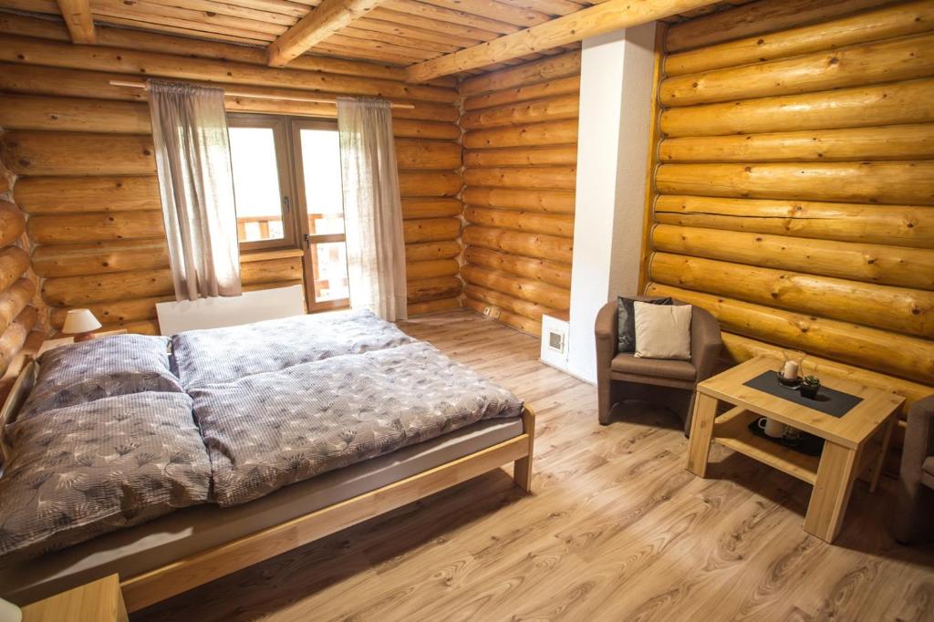 - une chambre avec un lit dans une cabane en rondins dans l'établissement Ubytovanie Dobšinská Ľadová Jaskyňa, à Stratená