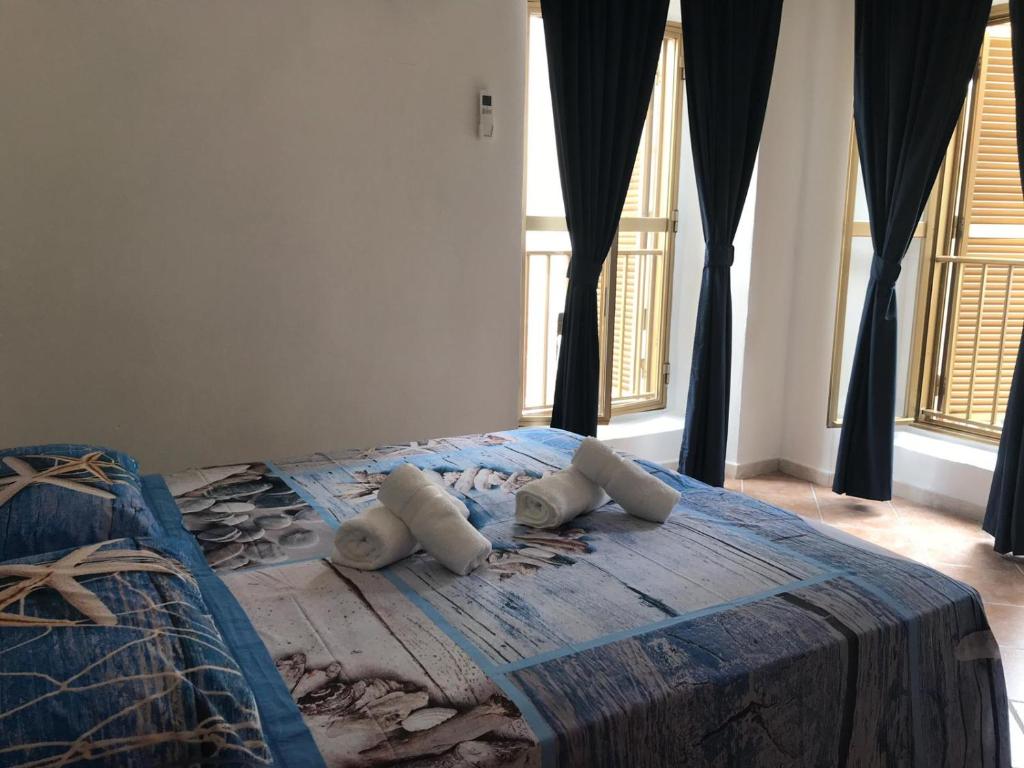 een slaapkamer met een bed met 2 kussens erop bij Bella Posada B&B in Buggerru