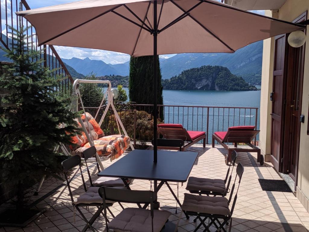 a patio with a table and chairs and an umbrella at SWEET VIEW in Varenna