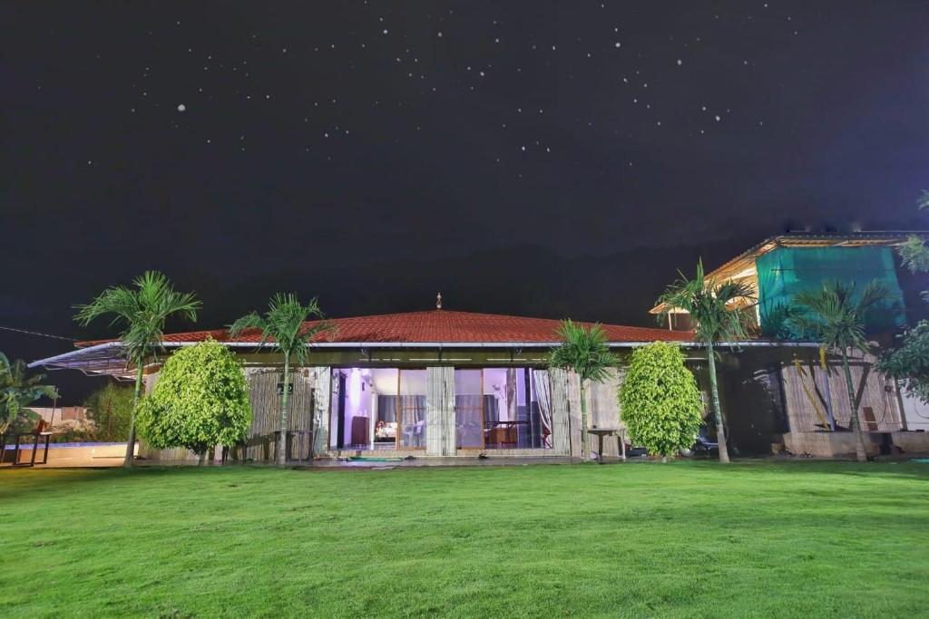 ein Haus mit grünem Hof in der Nacht in der Unterkunft 3BHK Mountain View Villa for Groups in Lonavla
