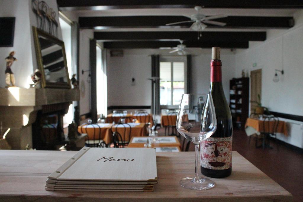 a bottle of wine sitting on a table with a wine glass at Les saladelles in Salin-de-Giraud