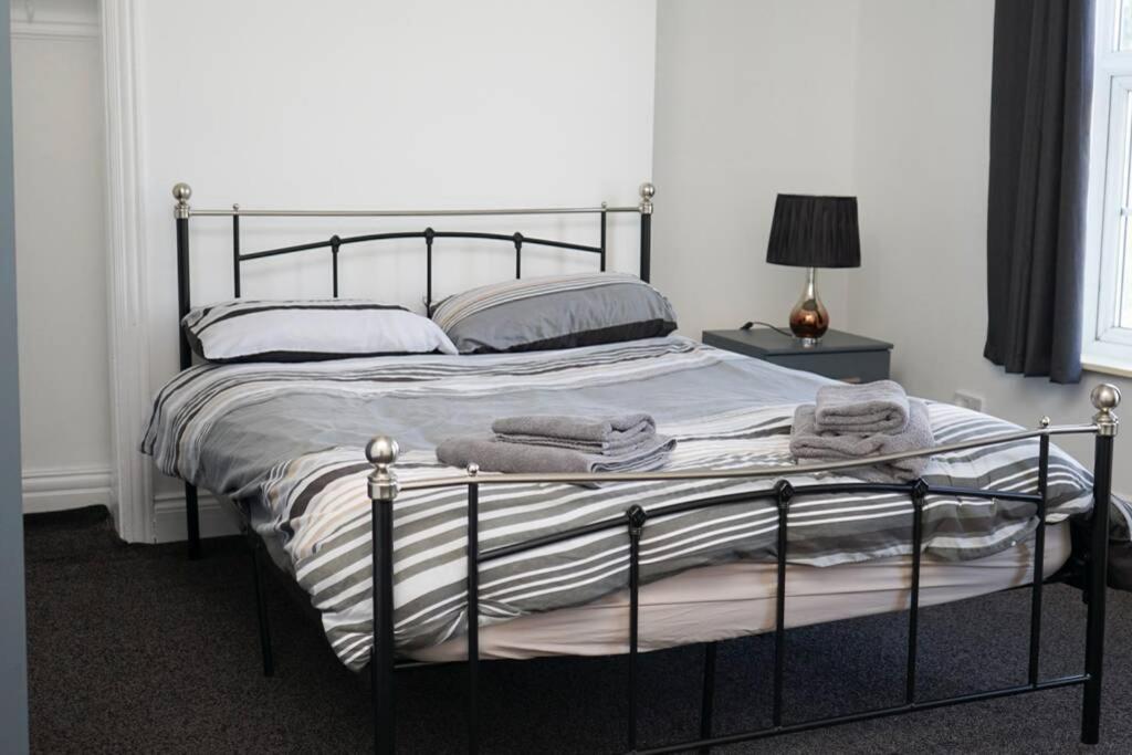 a bedroom with a large bed with a metal frame at Hullidays - University Side Lg 4 bed House in Hull