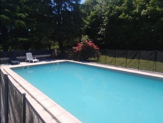 una gran piscina azul en un patio en Villa PARADISE en Bartrés
