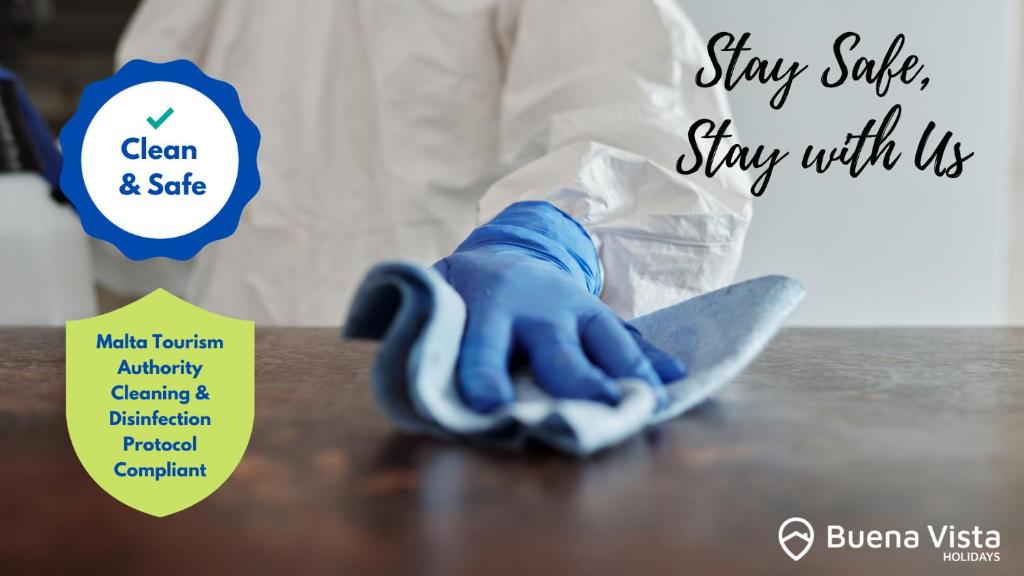 a hand in a blue glove on a table with a knife at Modern 2BR Sliema Apartment in Sliema