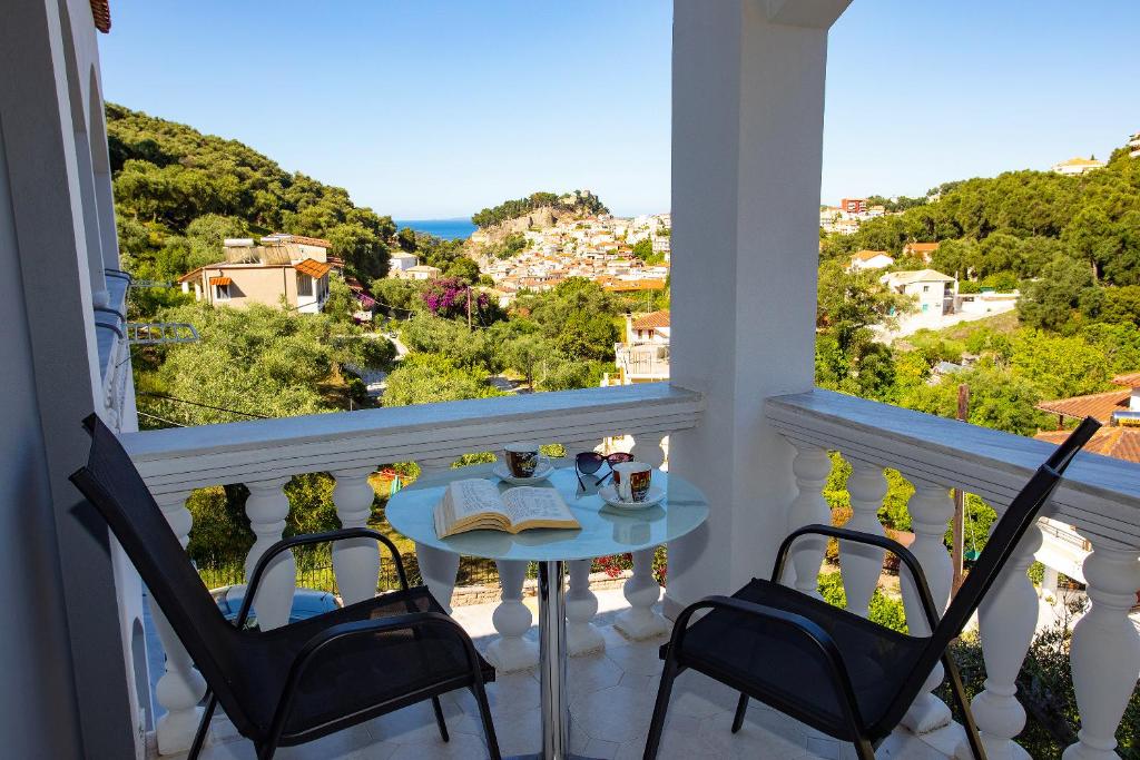 a balcony with a table and chairs and a view at Vassilis Studios in Parga