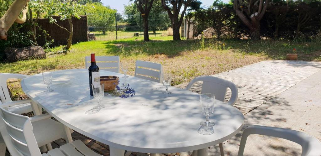 - une table blanche avec une bouteille de vin dans l'établissement TUMULUS - Villa 6 pièces, Jardin et Terrasse - S23, à Carnac