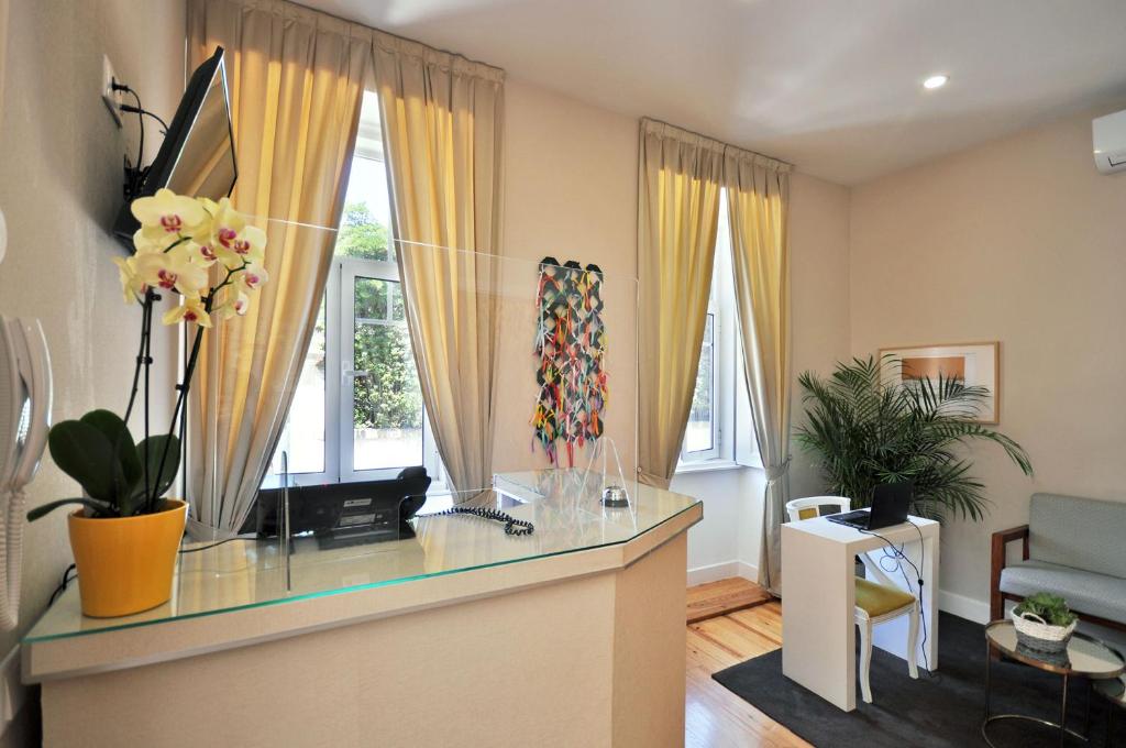 a living room with a counter with flowers on it at Porto Charming Hotel in Porto