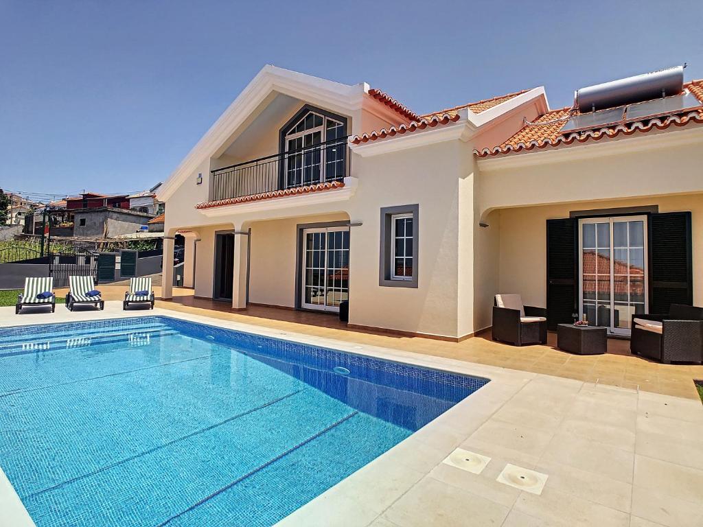a swimming pool in front of a house at Casa Mes Amis by LovelyStay in Relógio do Poiso