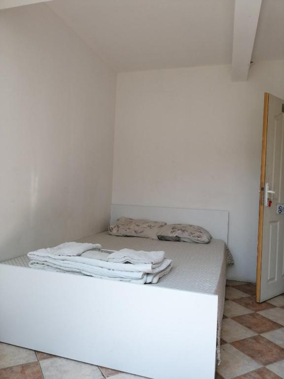 uma cama num quarto com uma parede branca em Пай Хост em Plovdiv