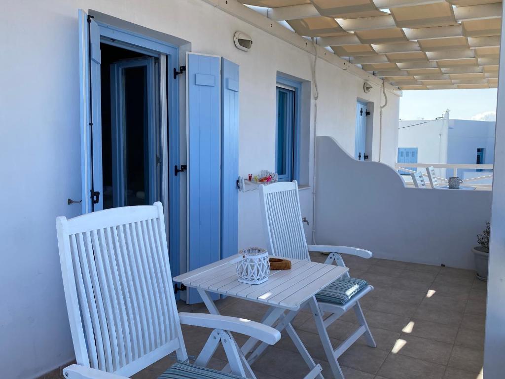 a table and two chairs on a balcony with a table at Studios Betty in Plaka Milou