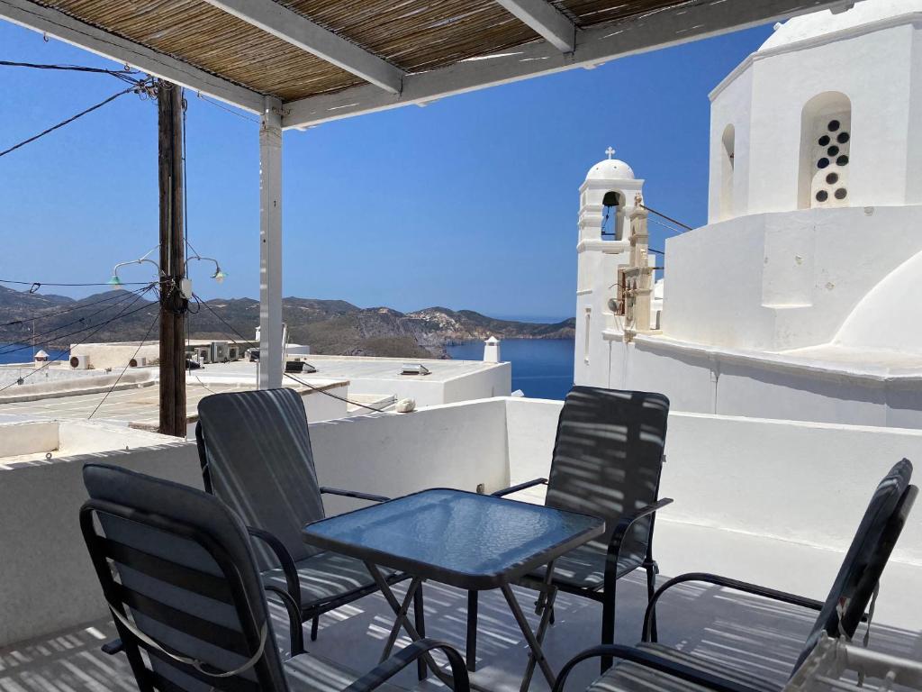 a table and chairs on a balcony with a lighthouse at Studios Betty in Plaka Milou