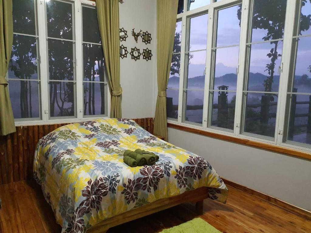 a bedroom with a bed with a pillow on it with windows at One&only homestay in Khao Kho