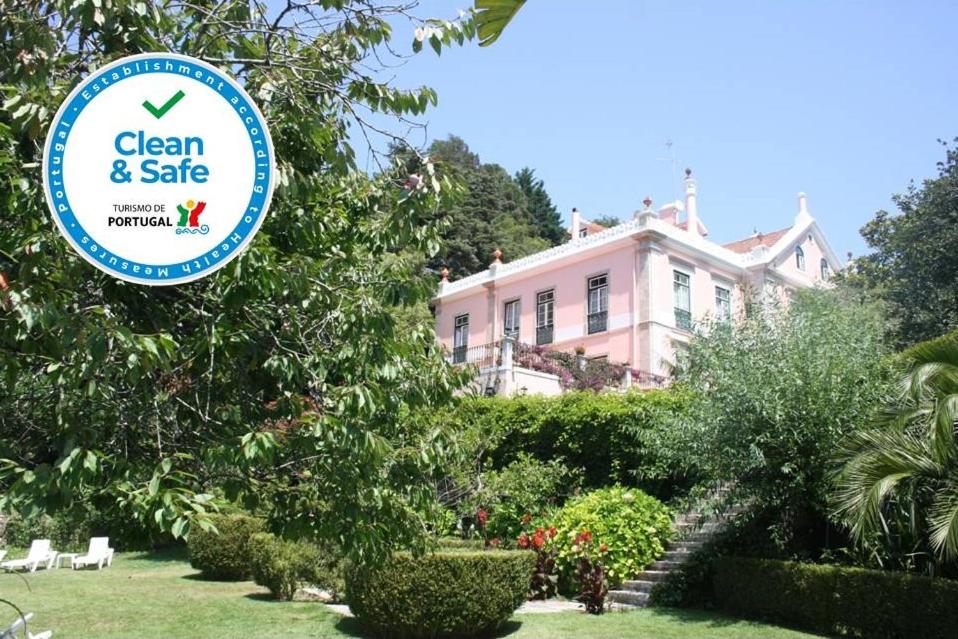 ein Schild für einen sauberen und sicheren Hof vor einem Haus in der Unterkunft Hotel Sintra Jardim in Sintra