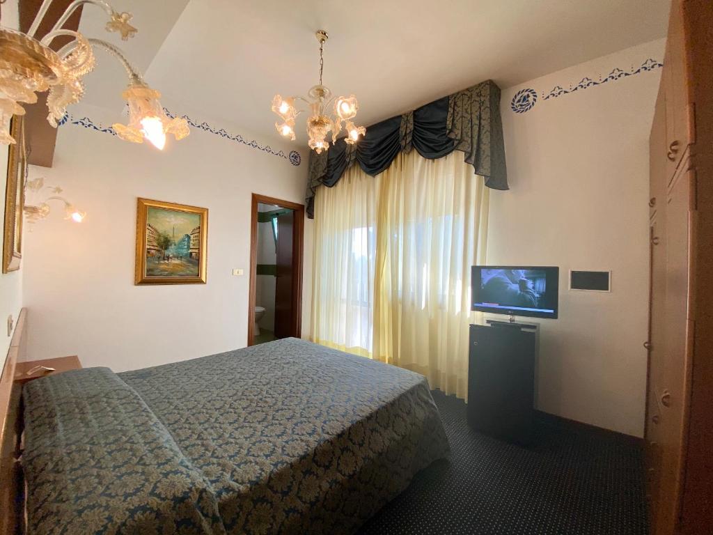 リド・ディ・イエゾロにあるHotel Floridaのベッドルーム(ベッド1台、薄型テレビ付)