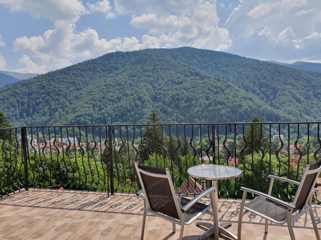 d'une terrasse avec une table, des chaises et une montagne. dans l'établissement Pensiunea TV Condor, à Sinaia