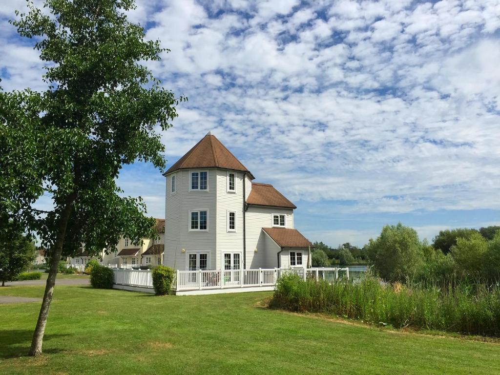 a large white house with a large yard at Windrush Turret Lodge in South Cerney