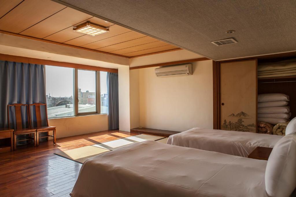 a hotel room with two beds and a large window at Hermit Crab B&B in Wuqi