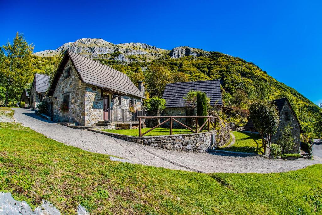 un edificio de piedra con una montaña en el fondo en Alpeggio Pruno, en Corfino