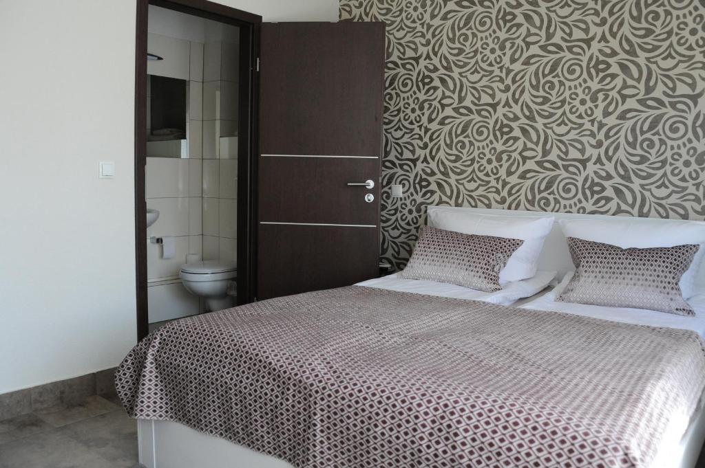 a bedroom with a large bed and a bathroom at Ferienzimmer Ellisee, kontaktloser Check-in in Friedrichshafen