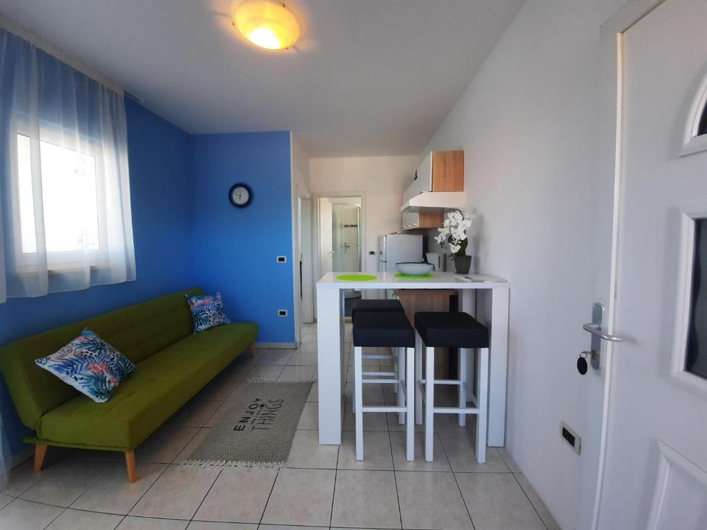 a living room with a green couch and a kitchen at Villa Doris YourCroatiaHoliday in Premantura