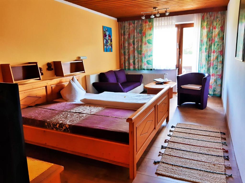 Habitación de hotel con cama y sala de estar. en Hotel/Pension Rosengarten en Franking