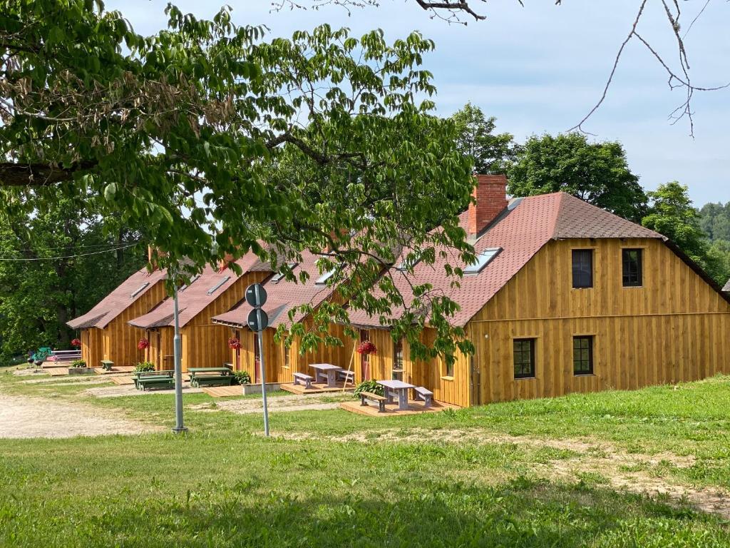 eine große Holzscheune mit Picknicktischen davor in der Unterkunft Kuutsemäe Puhkekeskus in Otepää