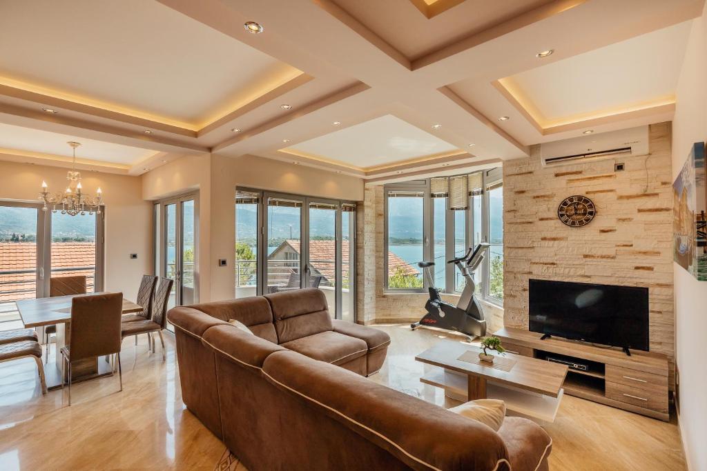 a living room with a couch and a television and a table at Apartmani Jelena in Tivat