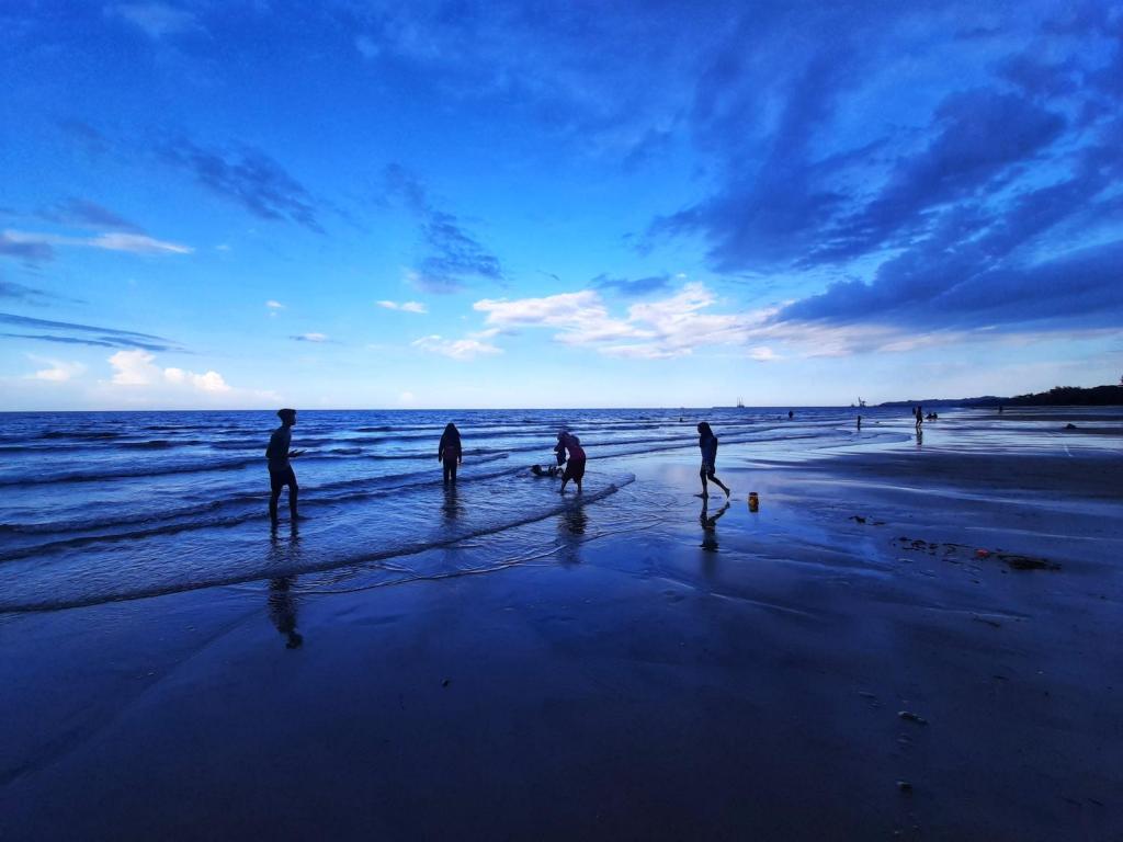 a group of people playing in the water on the beach at Samsuria Private Beach Front in Kuantan